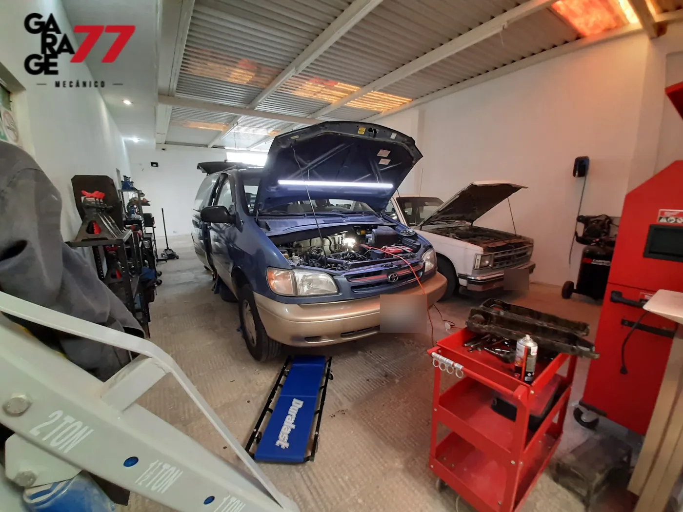 Interior del taller Garage77 con autos en servicio